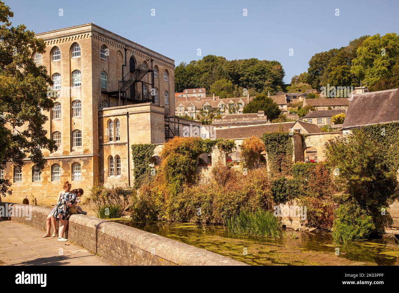 People on the walk along the banks of the river Avon in Bradford on Avon Wiltshire with a view of the old Abbey mill Stock Photo
