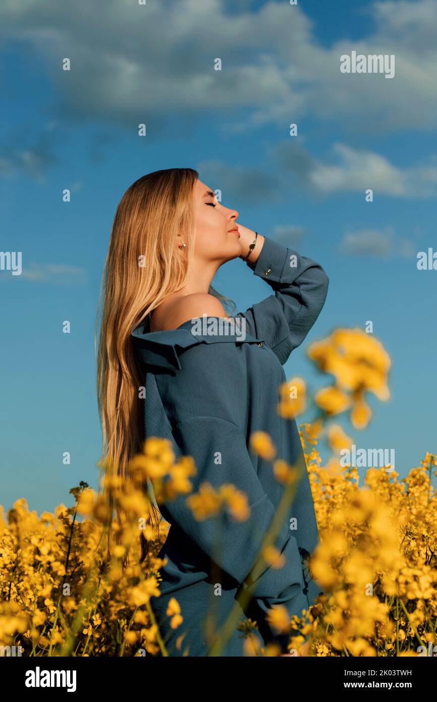 Portrait of a young girl in a rapeseed field at sunset Stock Photo - Alamy