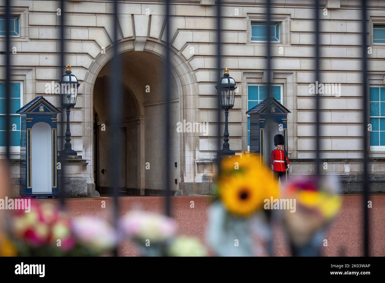 Buckingham Palace, London, UK – Friday 9th September 2022 – Soldiers stand guard behind the railings at Buckingham Palace which are now covered in flowers from the public as Britain mourns the death of Queen Elizabeth II. Photo Horst A. Friedrichs Alamy Live News Stock Photo