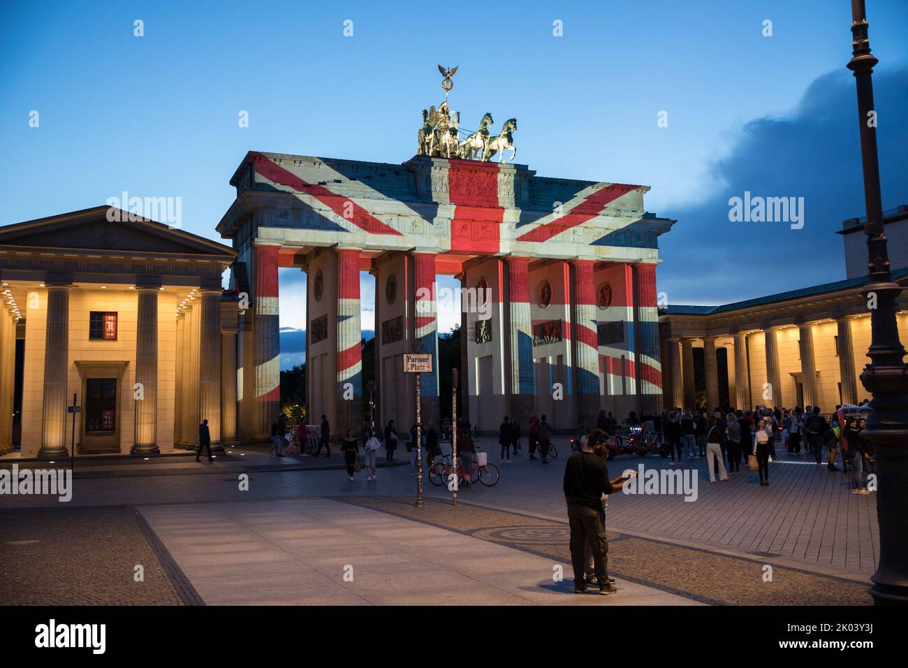 In Germany's Capital Berlin, the Brandenburg Gate was lit with the Union Flag on the evening of September 9, 2022, in mourning of Queen Elizabeth II. Many people gathered at Pariser Platz to express their solidarity. Queen Elizabeth II. had driven through the Brandenburg Gate in 2015 with Prince Philip in her limousine after saying goodbye at Pariser Platz. Queen Elizabeth II. first came to Berlin, which was still divided at the time, in 1965, as the first British head of state since the Second World War, where she was welcomed by an audience of at least one million people. At the time, she no Stock Photo
