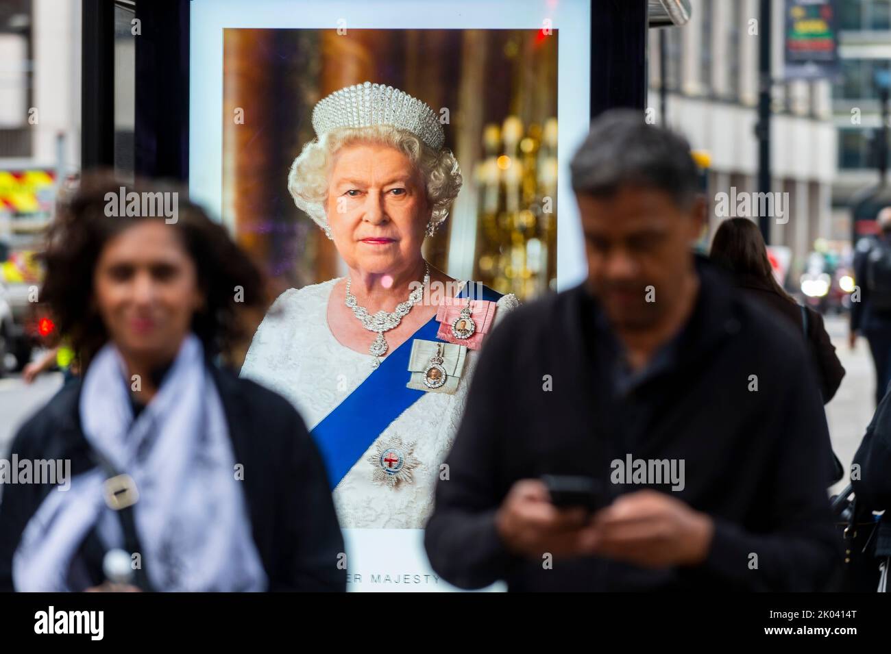 London, Britain. 9th Sep, 2022. People walk past a screen commemorating Britain's Queen Elizabeth II in London, Britain, on Sept. 9, 2022. Queen Elizabeth II, Britain's longest-reigning monarch in history, has died aged 96, Buckingham Palace announced on Thursday. Credit: Stephen Chung/Xinhua/Alamy Live News Stock Photo
