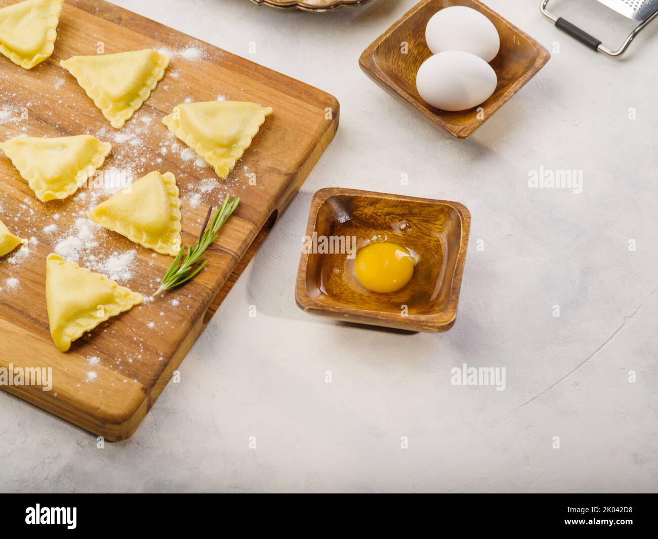 Cooking homemade Italian ravioli on a wooden cutting board on a white ...