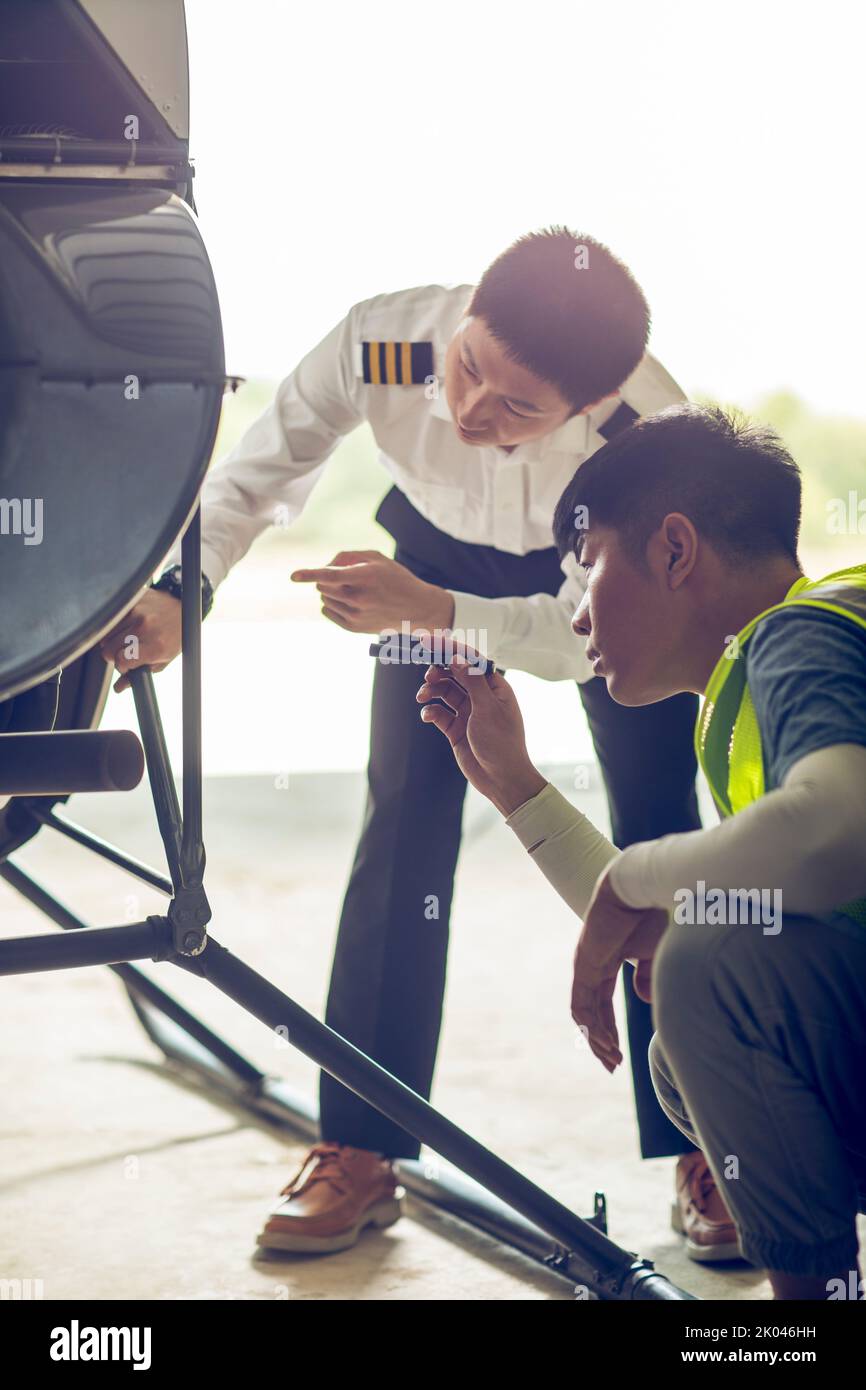 Chinese airplane mechanic checking helicopter Stock Photo
