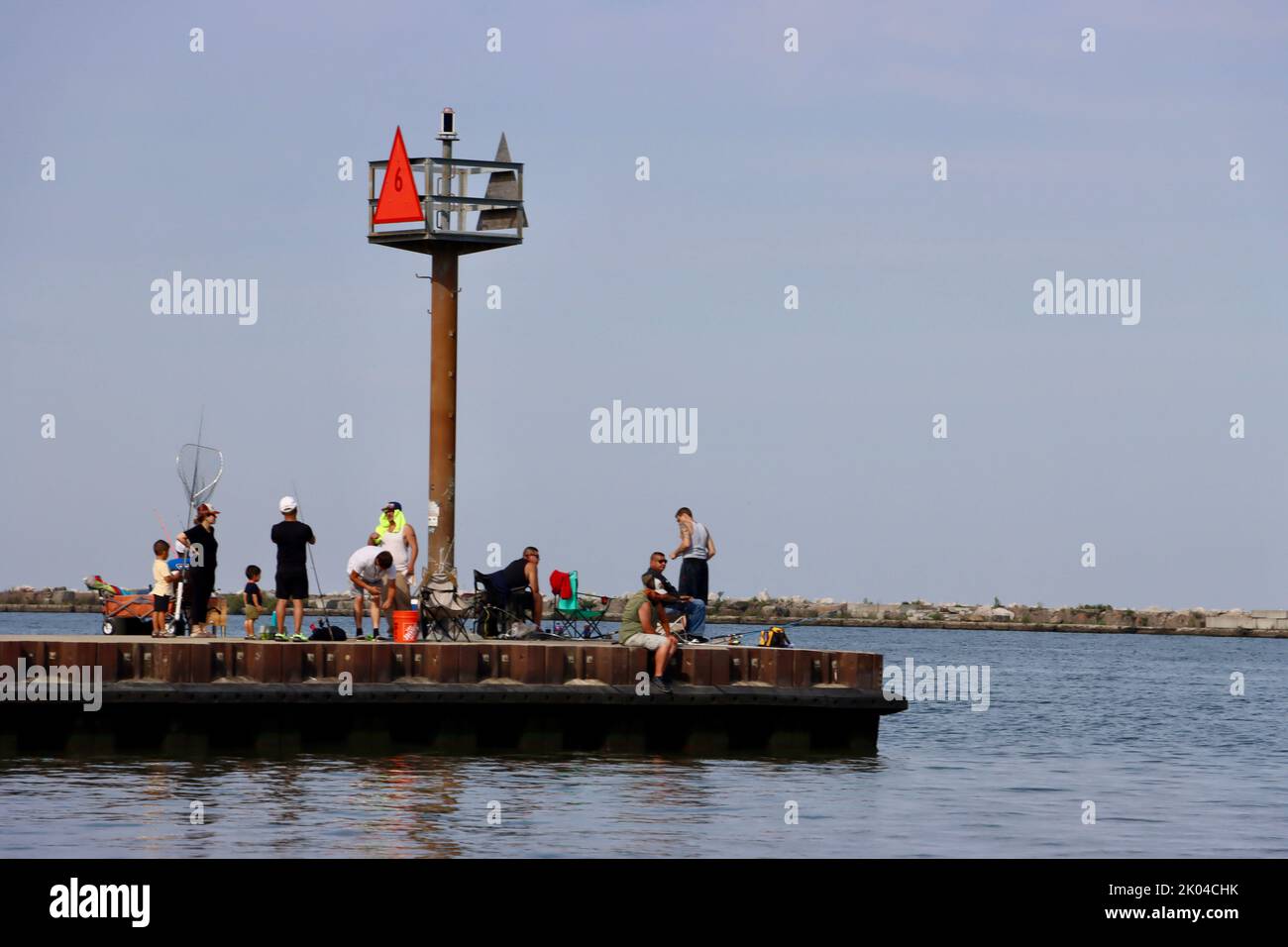 Fishermen on pier going out from historic coast guard station in Cleveland harbor Stock Photo