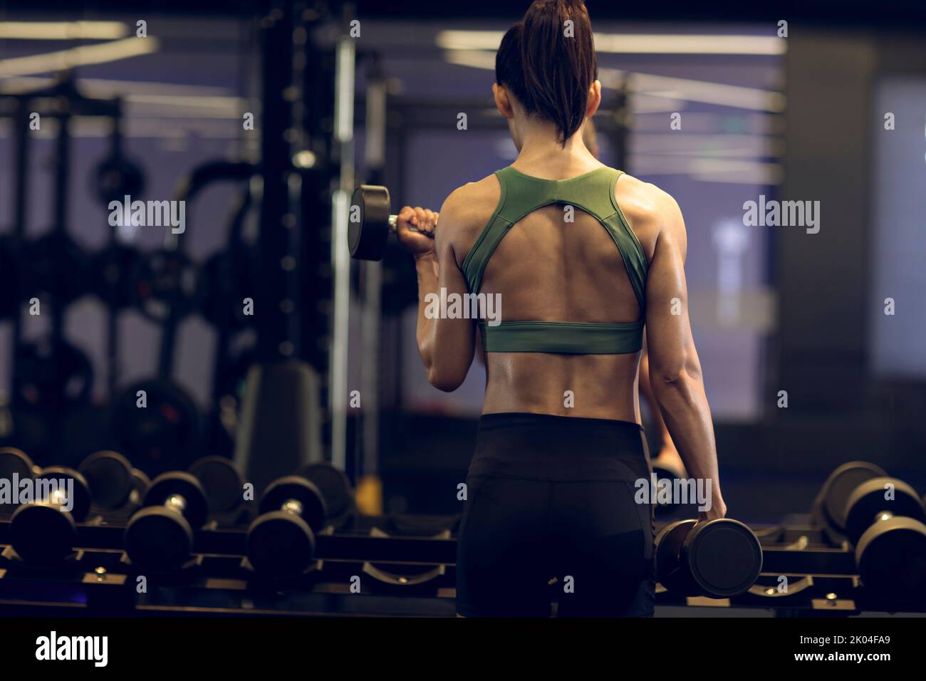 Young Chinese woman working out with dumbbell at gym Stock Photo