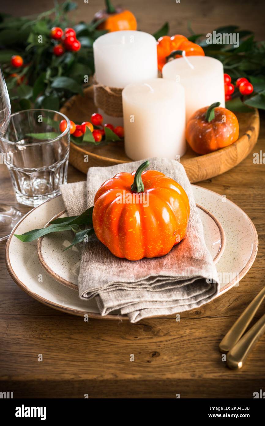 Autumn table setting with plate, pumpkin and candles Stock Photo - Alamy