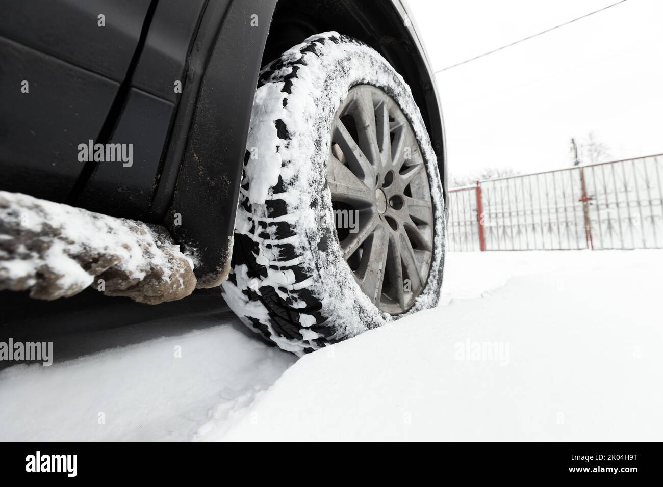 Snowy wheel of SUV car standing in a snowdrift on a winter day Stock Photo