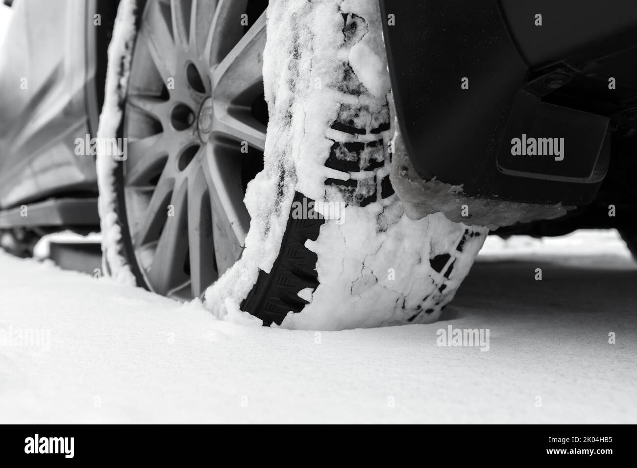 Close-up photo of snowy car wheel on snow tire with metal studs Stock Photo