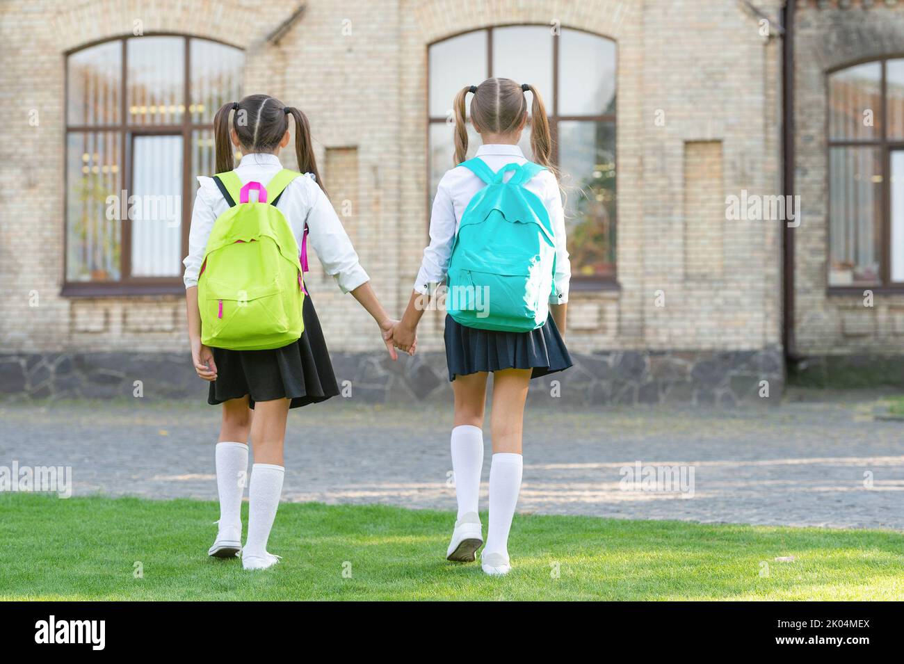 back view of two teen children with school backpack walking together ...