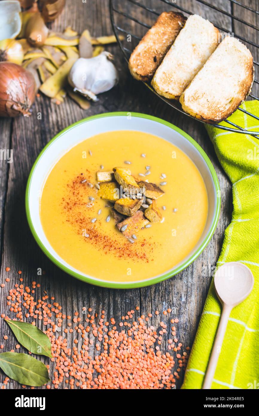 Vegan soup of red lentils, potatoes, garlic, onion, bay leaf, plant