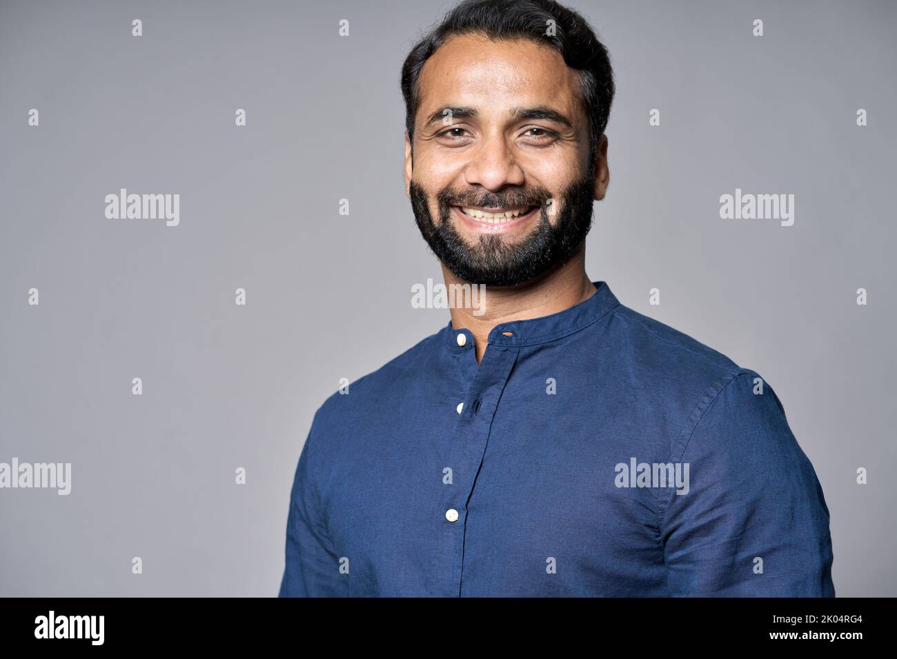 Smiling indian business man executive isolated on gray, headshot portrait. Stock Photo