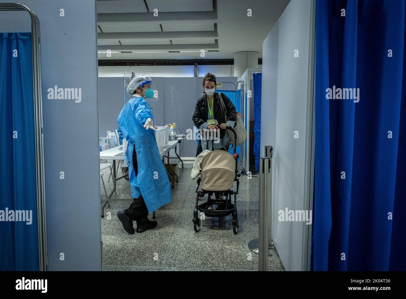 A staff wearing a Personal protective equipment (PPE) guides the the
