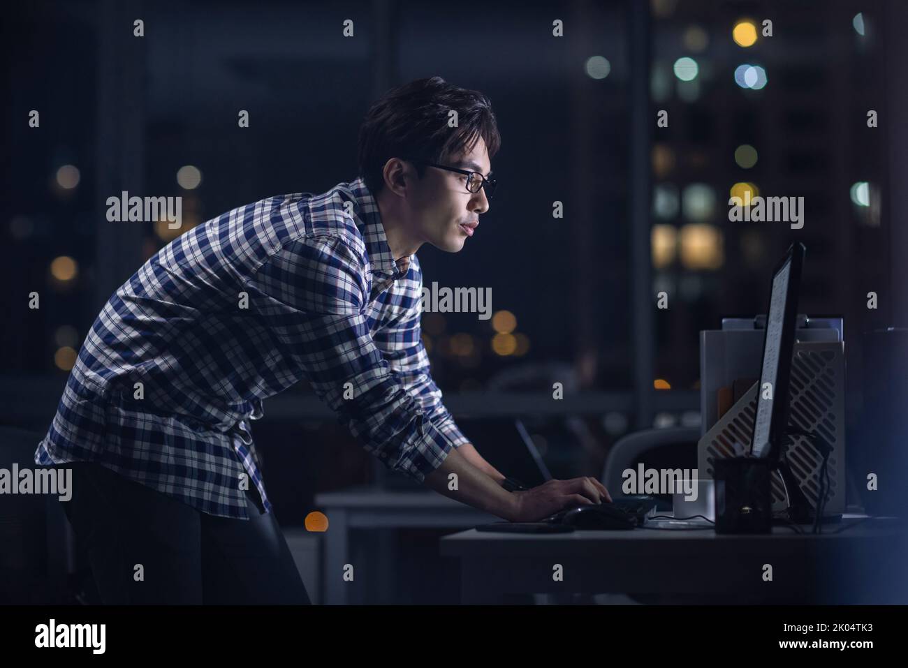 Chinese IT worker working in office at night Stock Photo