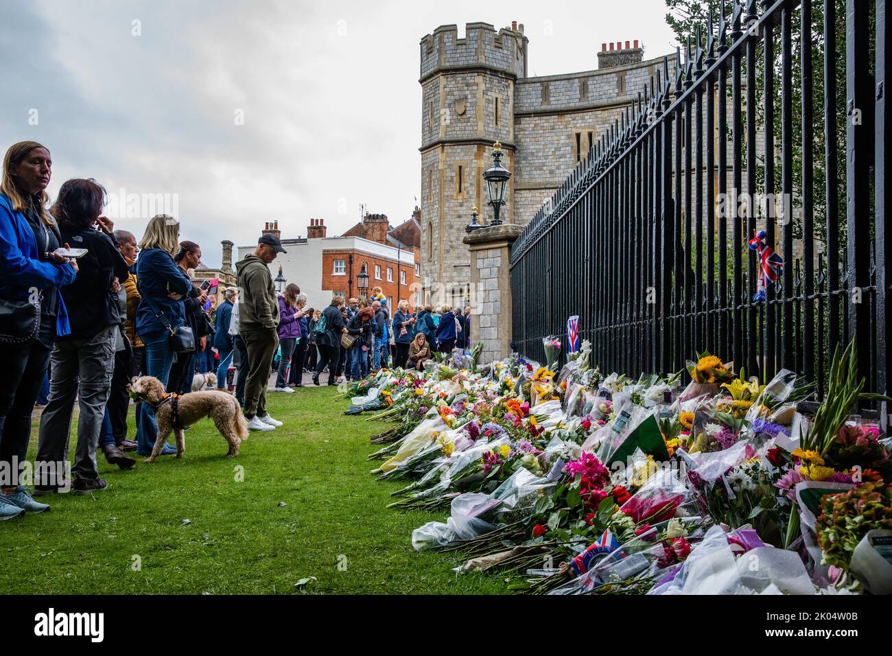 Windsor, UK. 9th September, 2022. Visitors look at floral tributes left outside Cambridge Gate at Windsor Castle a day after the death of Queen Elizabeth II. Queen Elizabeth II, the UK's longest-serving monarch, died at Balmoral aged 96 after a reign lasting 70 years. Credit: Mark Kerrison/Alamy Live News Stock Photo