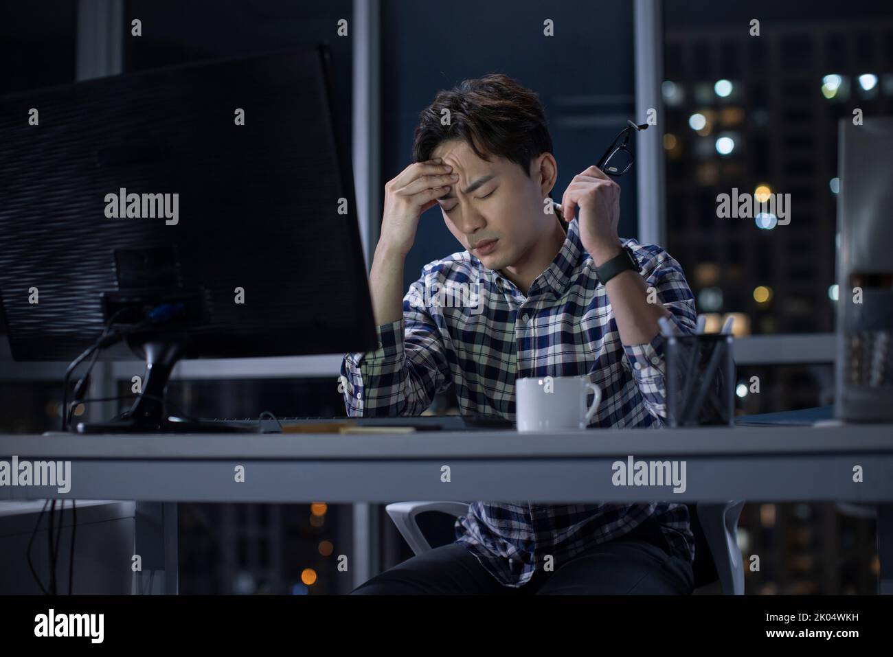 Chinese IT worker working in office at night Stock Photo