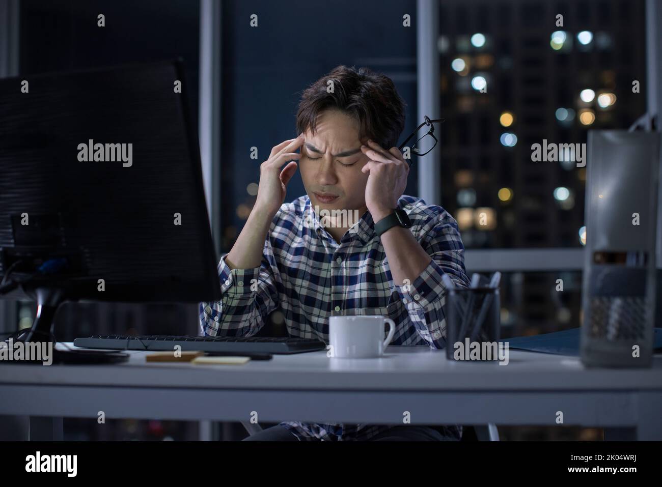 Chinese IT worker working in office at night Stock Photo