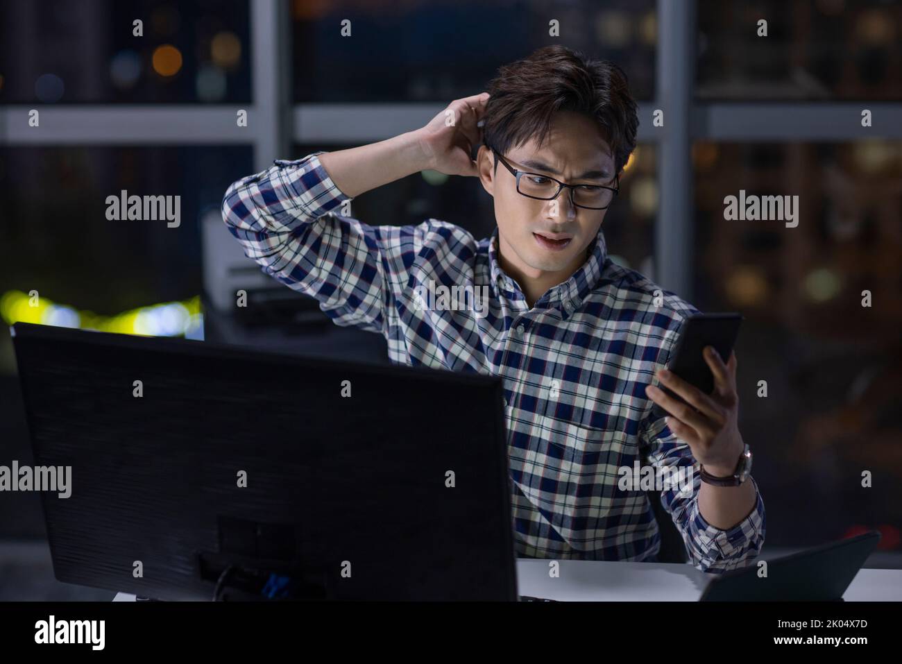 Chinese IT worker working in office at night Stock Photo