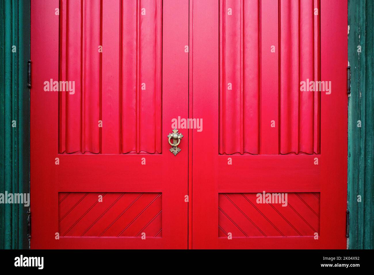 Red Wood Doors with Ornate Metal Handle Stock Photo