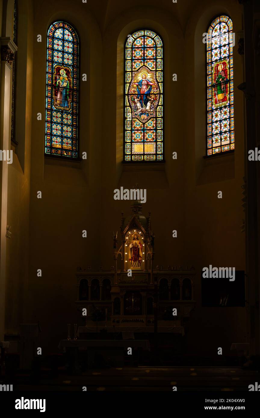 Stained-glass windows, the central one depicting the Assumption of the Virgin Mary. Blumental church in Bratislava, Slovakia. Stock Photo
