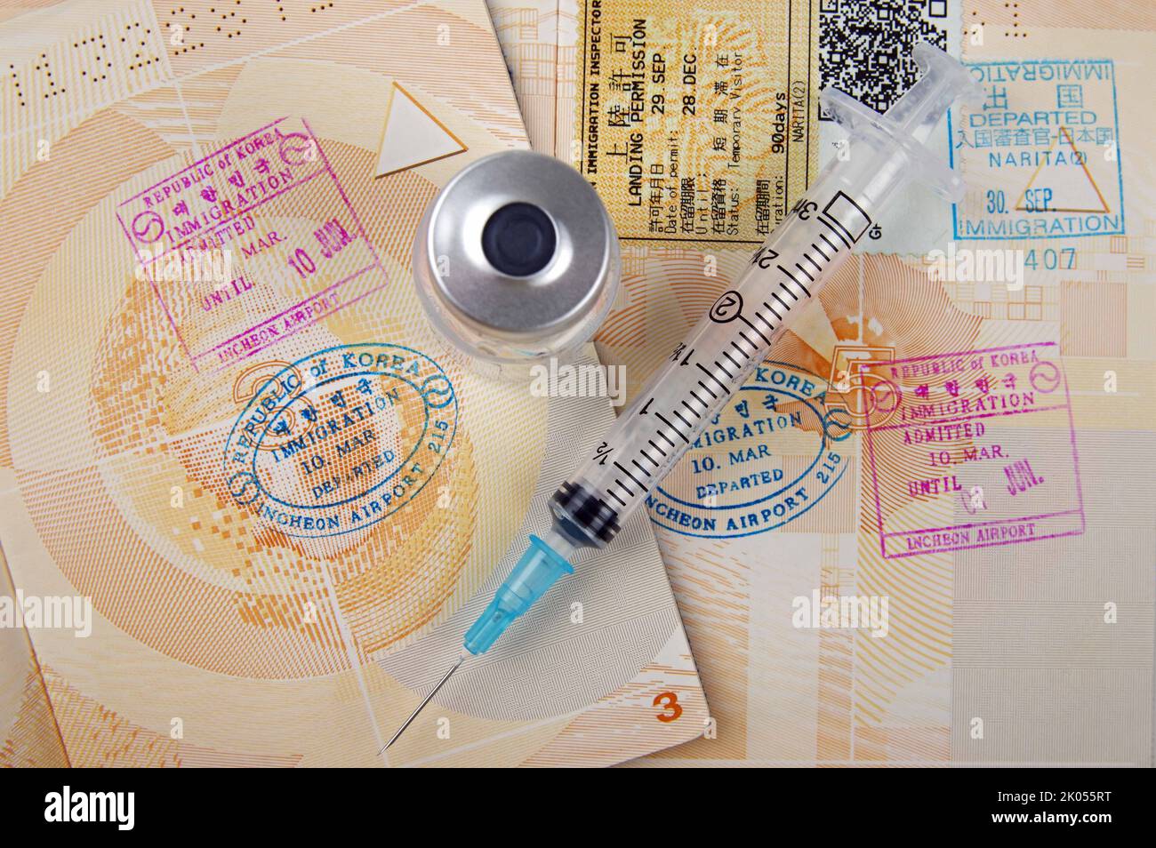 medical syringe and open passport pages Stock Photo