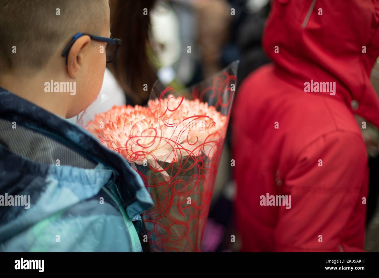 Festive bouquet. Flowers in child. Teaching brings flowers to teacher. Details of holiday. Stock Photo