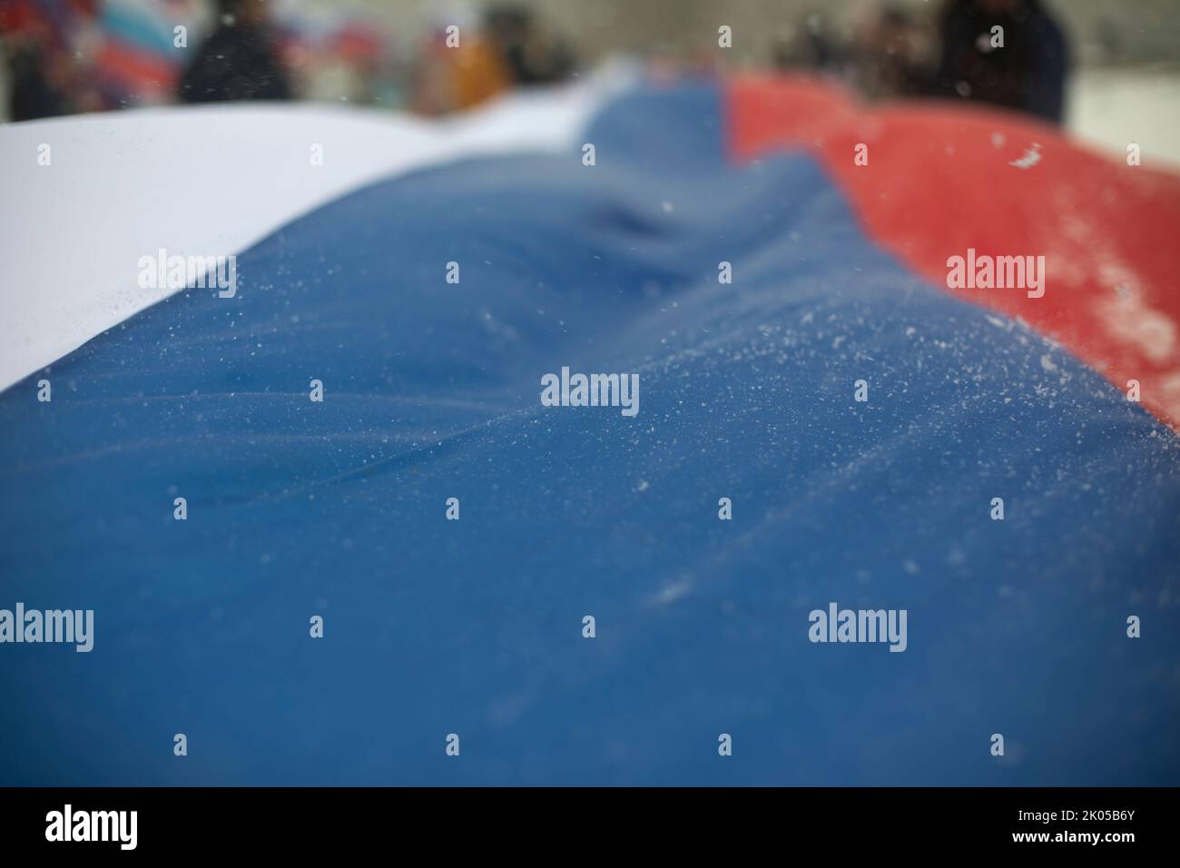 Flag of Russia in winter. Large cloth made of fabric. Symbol of state power in Russian Federation. Big rally in support of government. Stock Photo