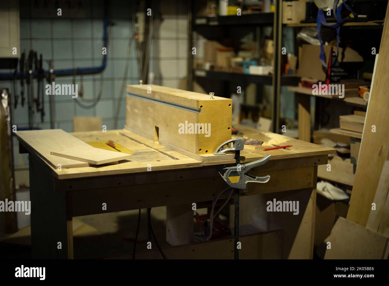Table in wood workshop. Furniture assembler's workplace. Boards lying on table. Details of work. Stock Photo