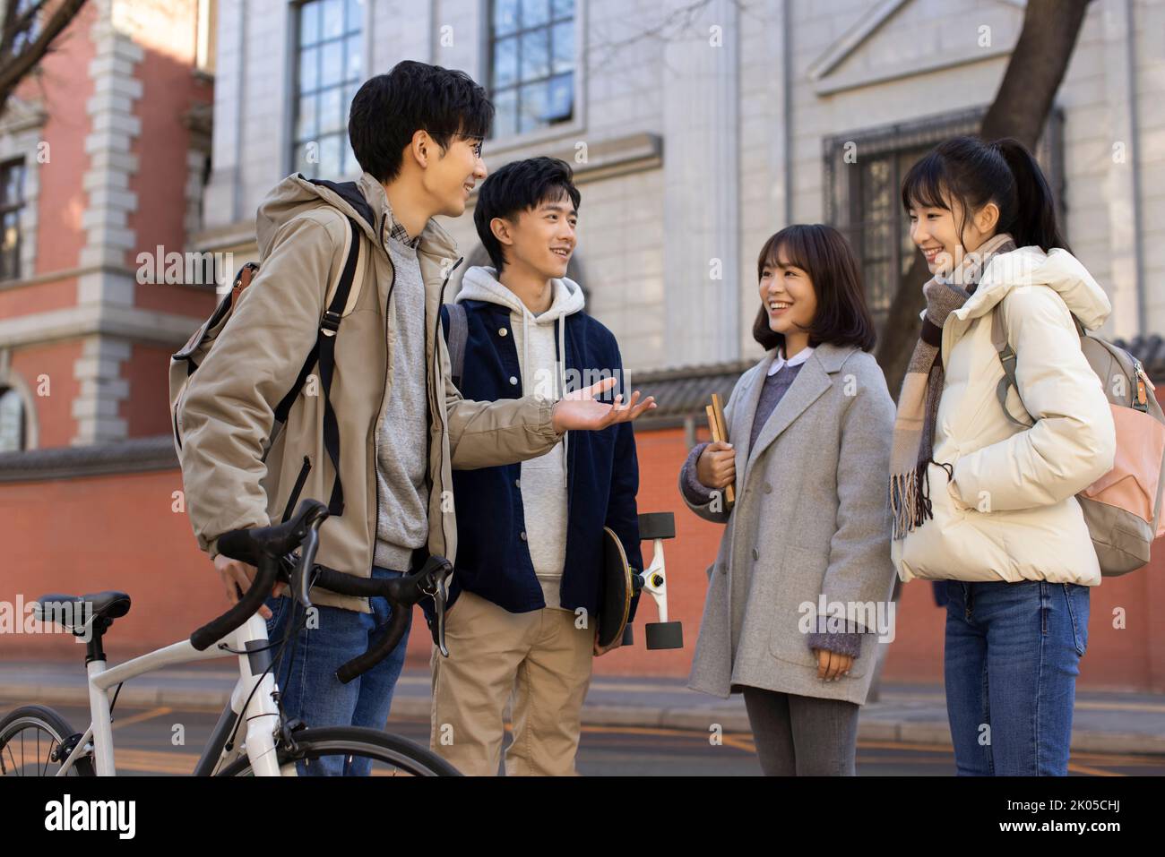 Happy Chinese college students talking on campus Stock Photo
