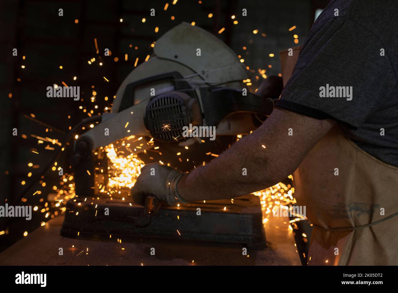 Circular saw in garage. Sparks from metal. Production of construction. Stock Photo