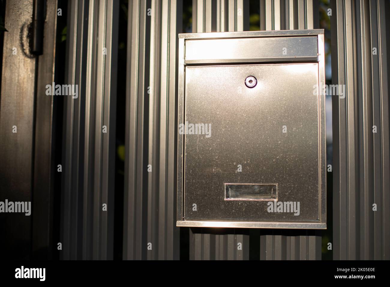 Mailbox on fence. Steel mailbox with lock. Fence details. Box made of