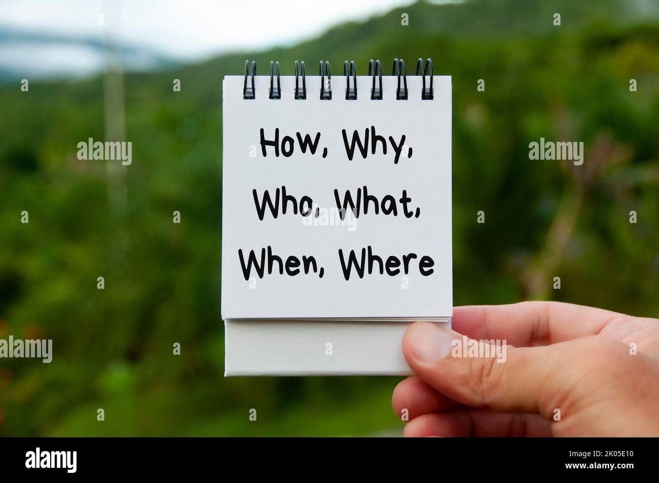 How, why, who, what, when and where text on calendar pad with blurred nature background. Fact finding concept. Stock Photo