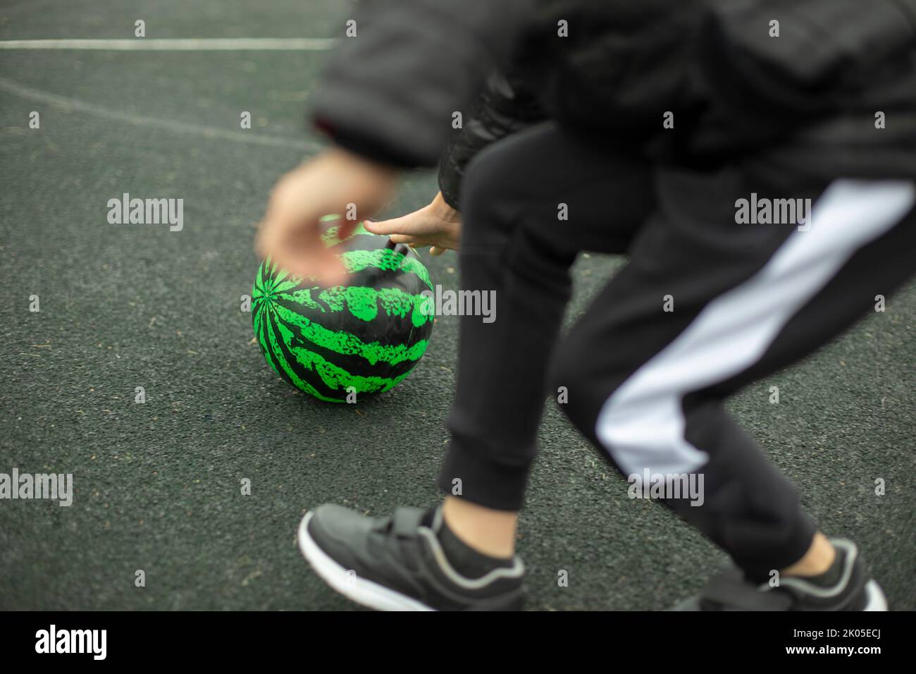 Relay for children. Sports game. Children roll meat around playground. Fun in summer. Competition for agility. Stock Photo