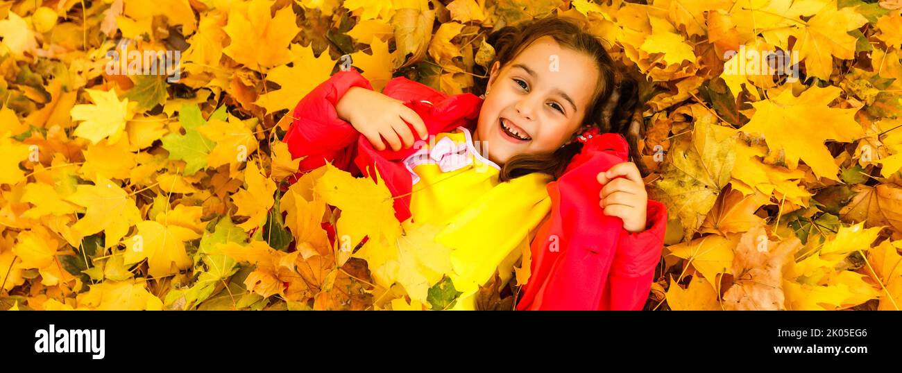 Happy little girl lies in yellow leaves in autumn park Stock Photo - Alamy