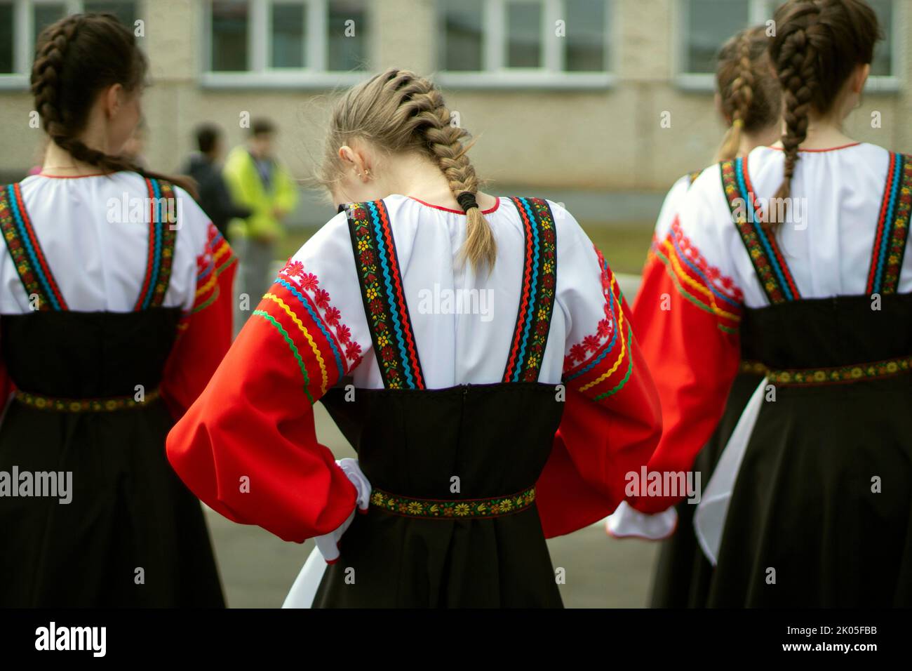 Girl in Russia in folk dress. Preparation for dance. Children perform on street with theatrical number. Folk style of clothing. Stock Photo