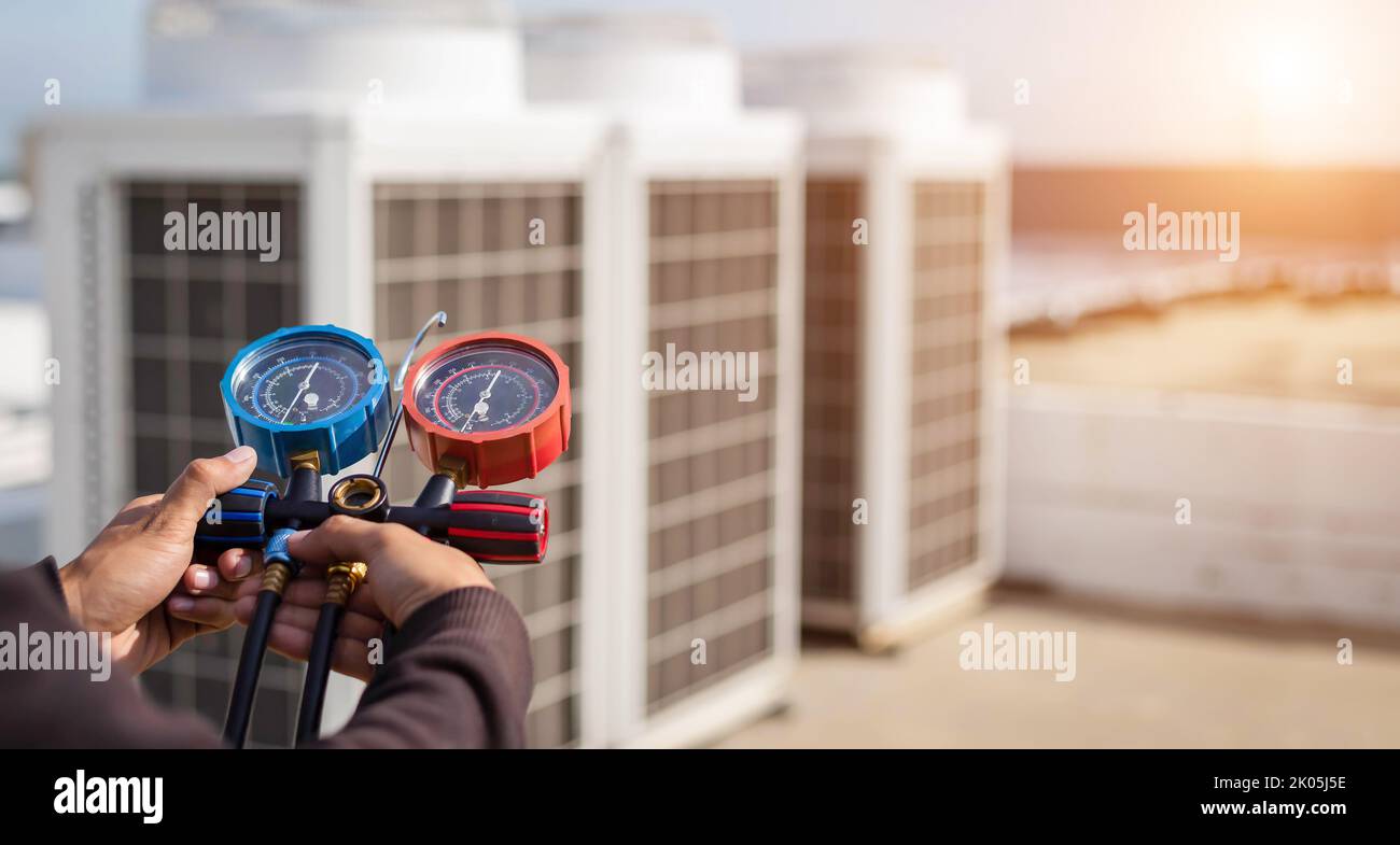 Air repair mechanic using measuring equipment for filling industrial