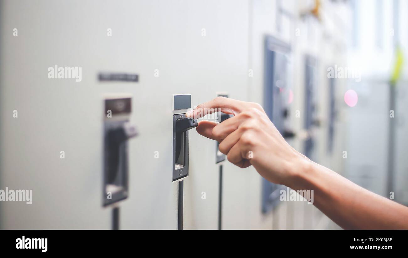 Engineers working to inspect and maintain electrical control cabinets. Stock Photo
