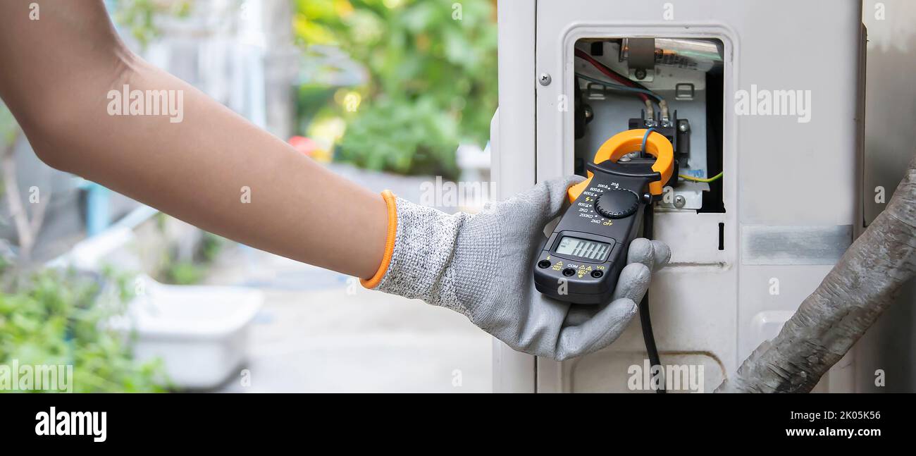 Air conditioner technician checking air conditioner operation Stock