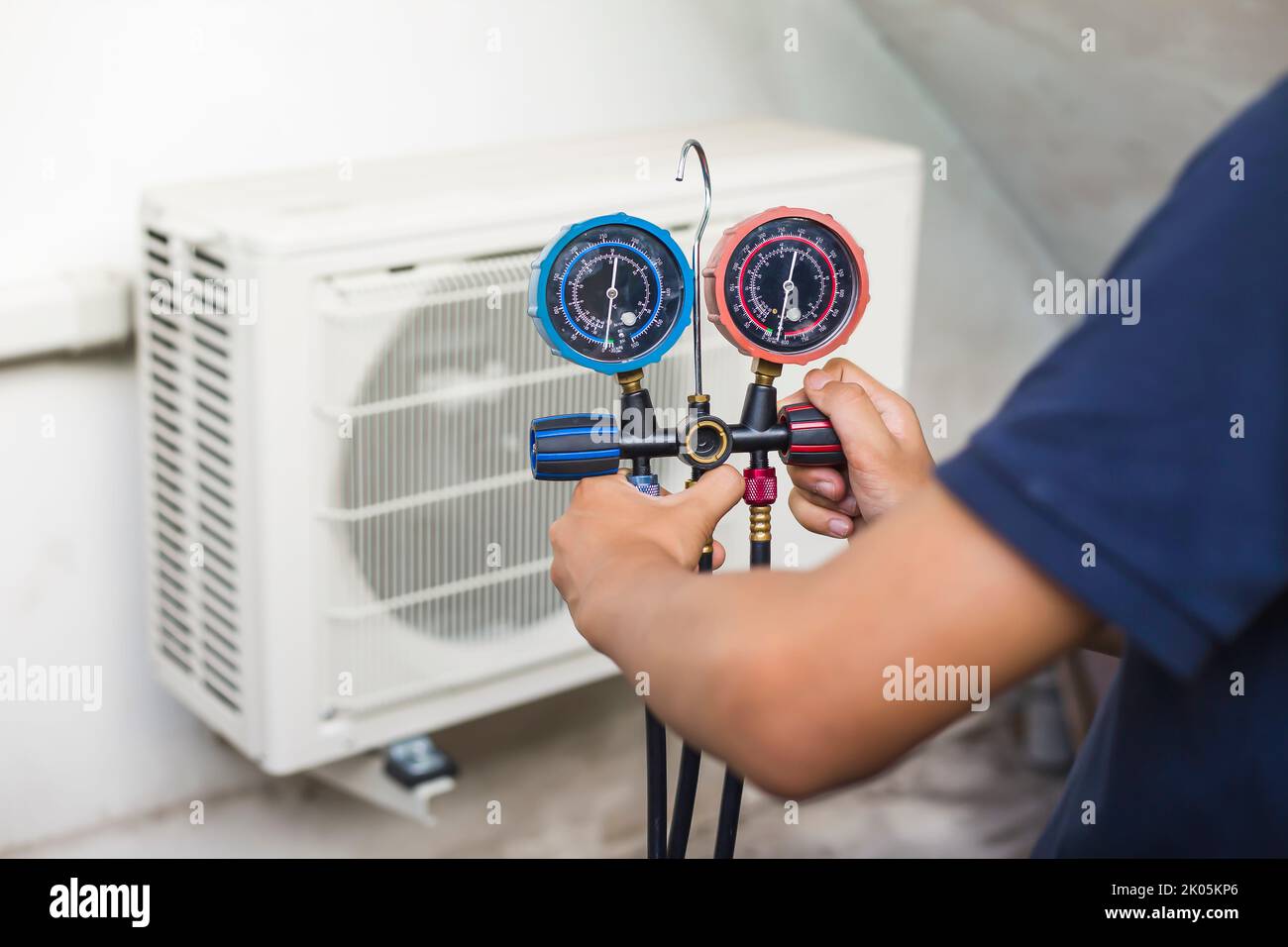 Air repair mechanic using measuring equipment for filling industrial