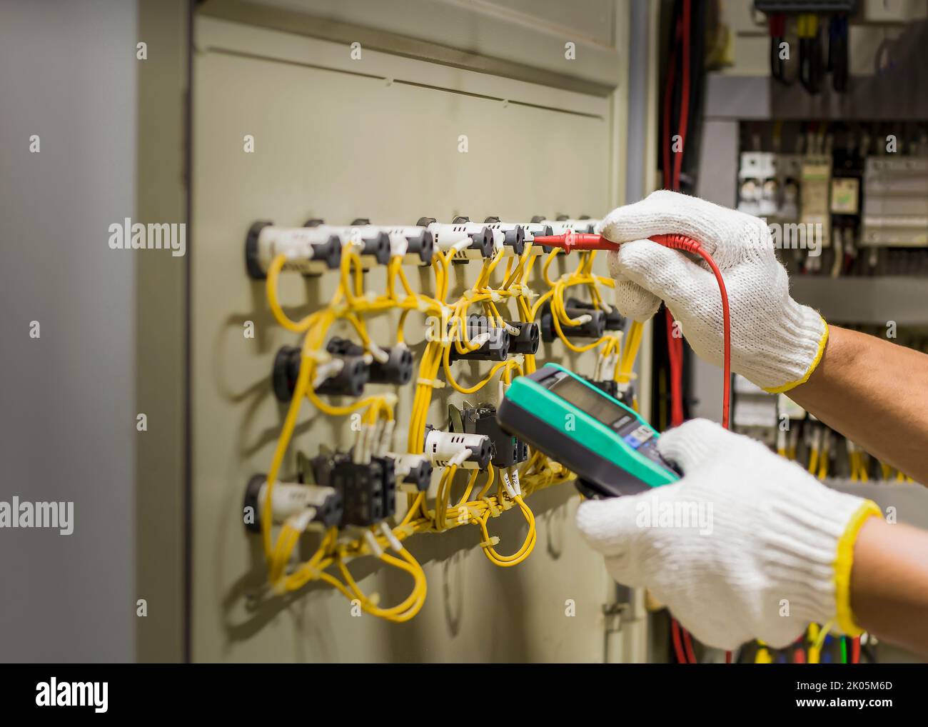 An electrical engineer is inspecting the operation of an electrical control cabinet. maintenance concept Stock Photo