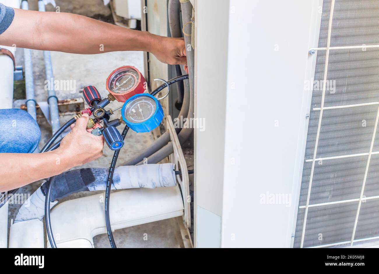Air repair mechanic using measuring equipment for filling industrial