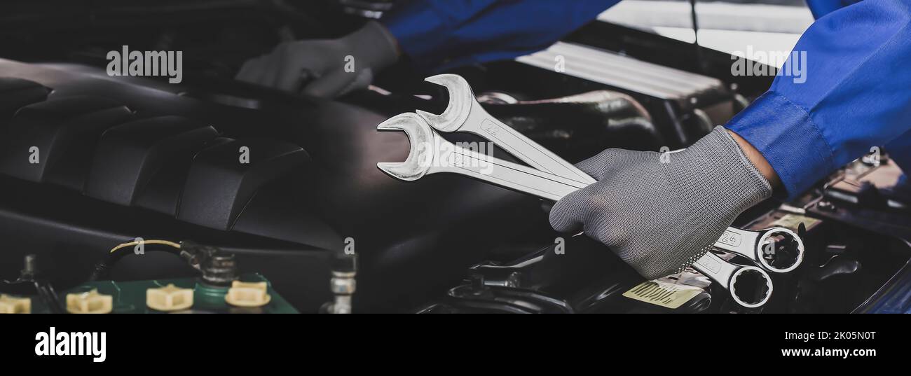 Mechanic works on the engine of the car in the garage.Concept of car