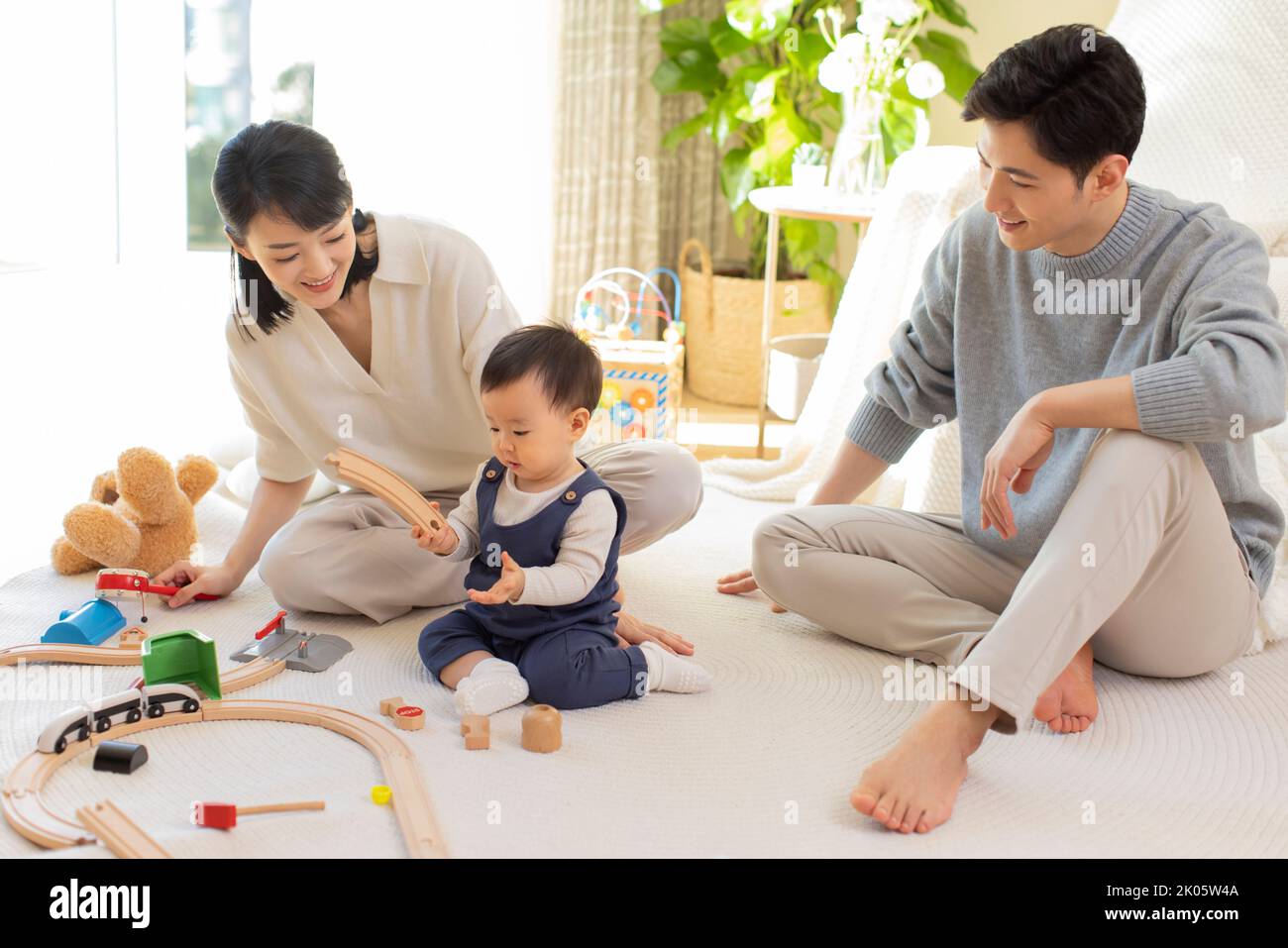 Young Chinese parents playing with baby at home Stock Photo Alamy