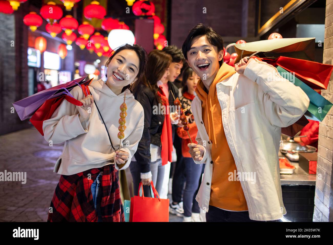 Young Chinese couple with candied haw celebrating Chinese New Year Stock Photo