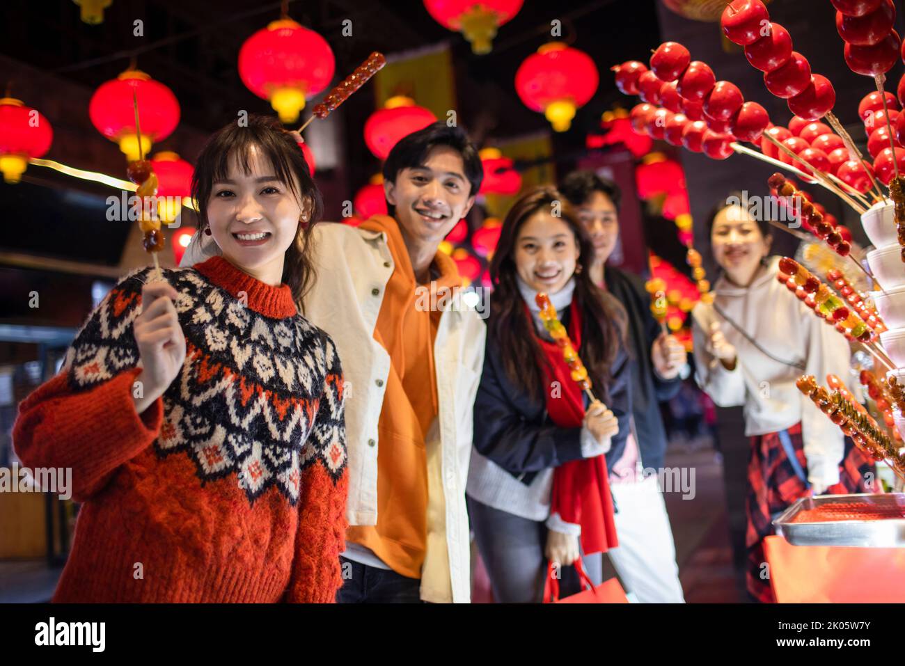 Young Chinese friends with candied haw celebrating Chinese New Year Stock Photo