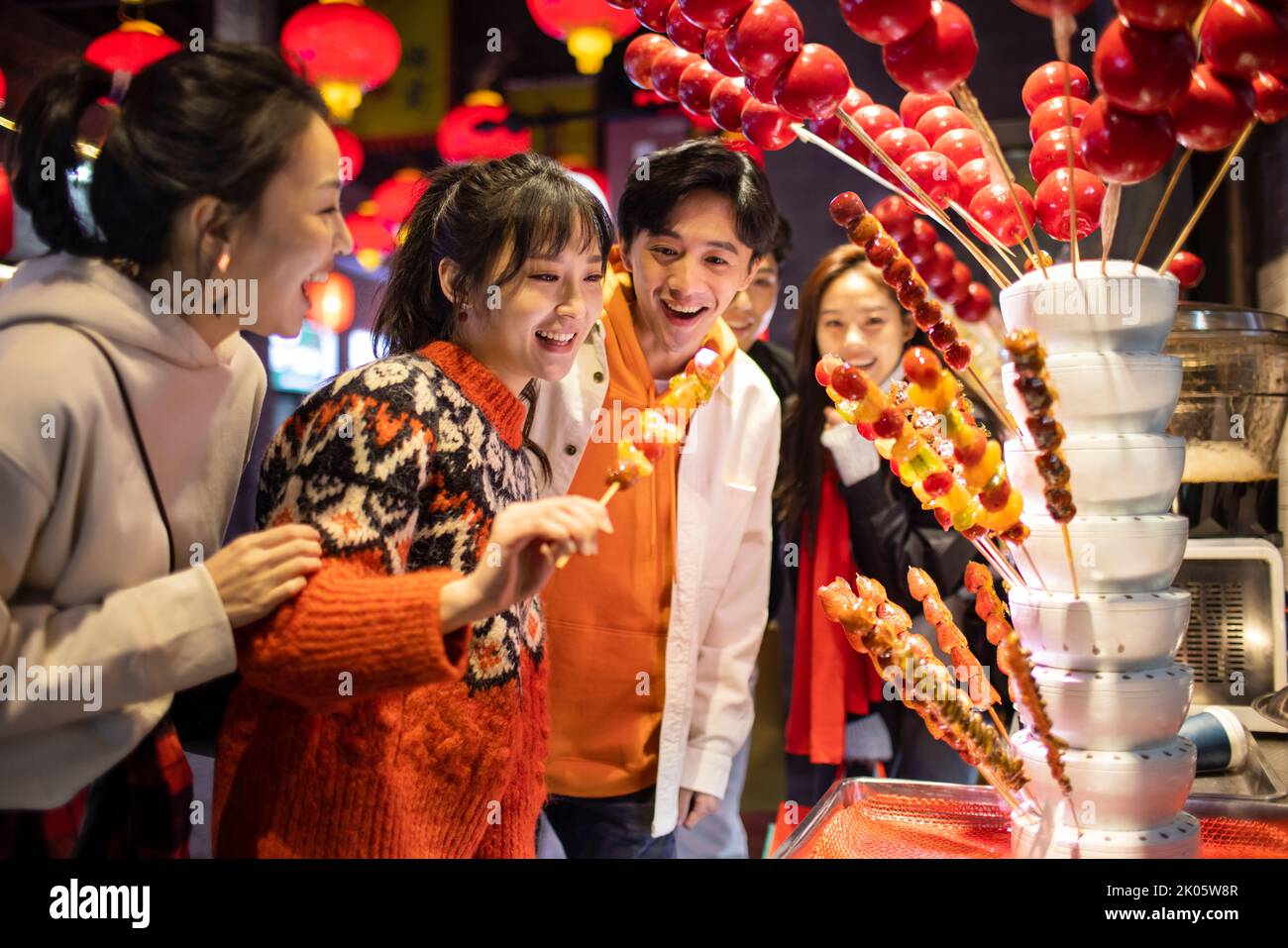 Young Chinese friends with candied haw celebrating Chinese New Year Stock Photo
