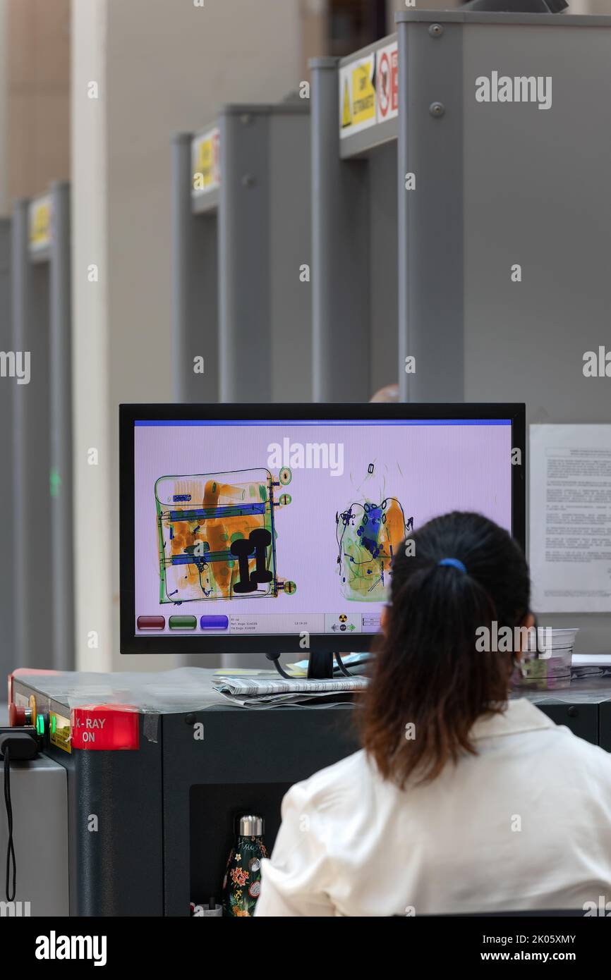 Security personnel checking bags and backpacks xrayed at the access