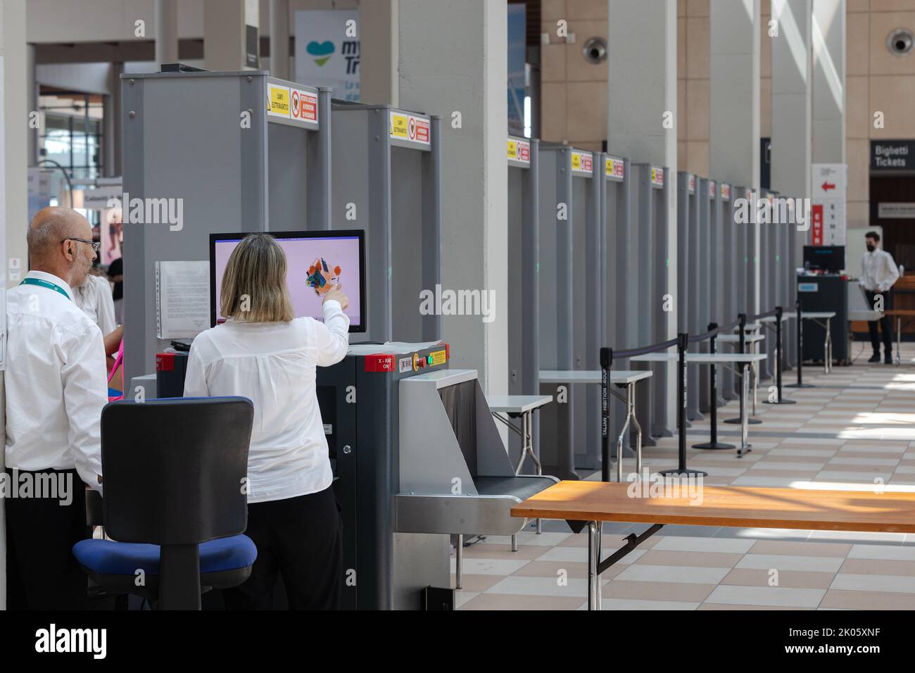 Security personnel checking bags and backpacks xrayed at the access