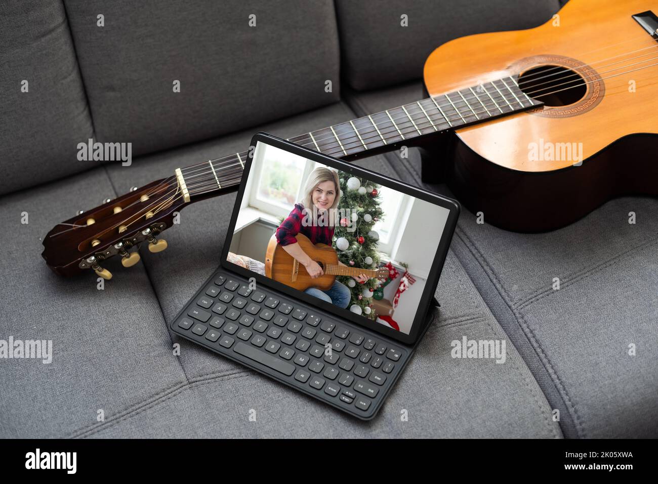 virtual guitar lesson. female musicians play together online in isolation because of the