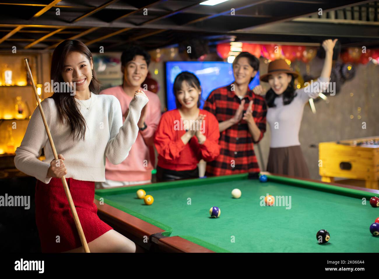 Happy young Chinese friends playing billiard together Stock Photo