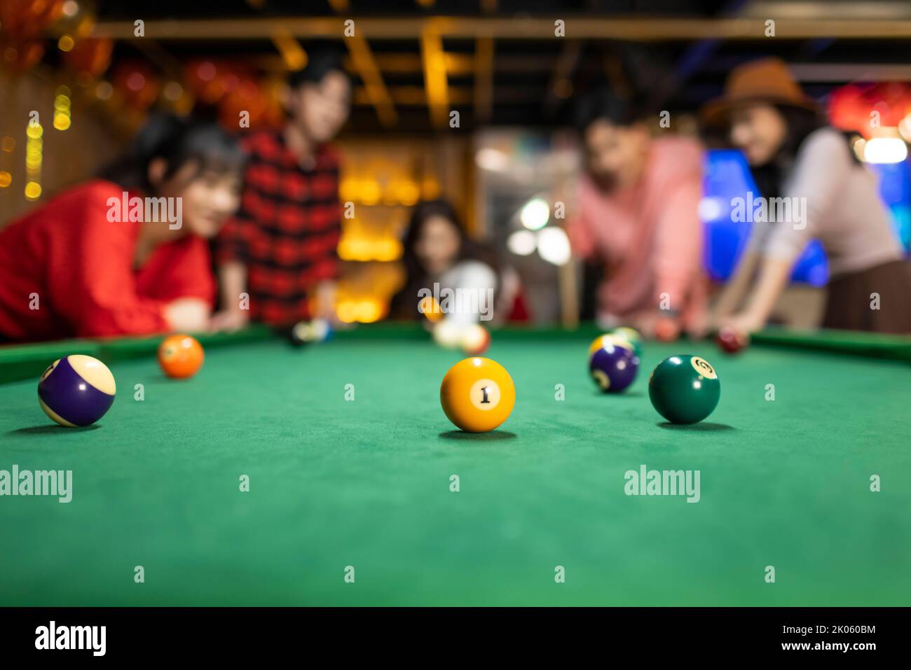 Happy young Chinese friends playing billiard together Stock Photo
